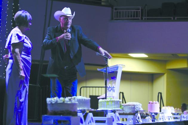 As Kaye Steele with Project:SAFE looks on, Dennis Salzman auctions off cakes during the 16th Annual Honey Do Auction, held at the Grand Casino Hotel &amp; Resort on Oct. 3. Countywide &amp; Sun/Natasha Dunagan