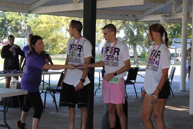 Runners in the top three receive awards from Prevention Specialist Kayla Woody at the Third Annual House of Hope Color Fun Run on Oct. 5. Shown, from left, are Woody, Mikal Verdine, Seminole; Gerald Yancey, Seminole; and unknown. Countywide &amp; Sun/Natasha Dunagan