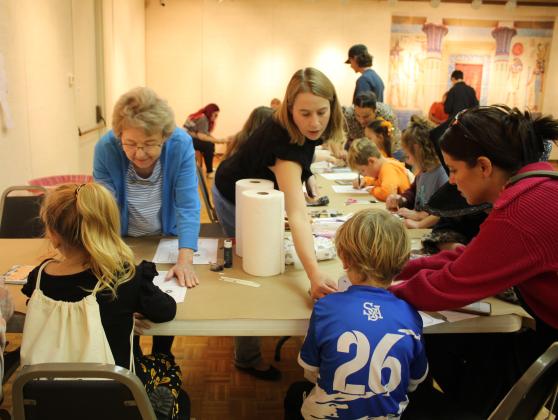 Mabee-Gerrer Museum of Art volunteers Eileen Hargrove and Greta Lynn Baxter help Freya McAlvain, 6, and Vaughn Ervin, 6, of Shawnee, respectively, to write their names in hieroglyphics during Mummy Day at the museum on Oct. 26. Ervin's mother, Rachel Ervin, is also assisting. Countywide &amp; Sun/Natasha Dunagan