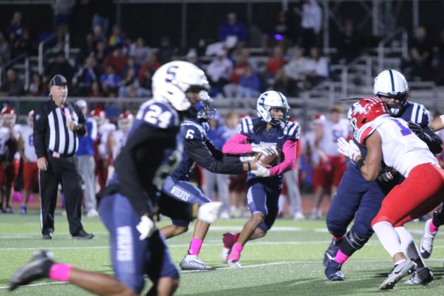 Shawnee junior Zyron Campbell hands off to senior Deetrick Beavers during the first quarter of the homecoming game with Durant on Oct. 18. The Wolves won, 28-7. Countywide &amp; Sun/Natasha Dunagan