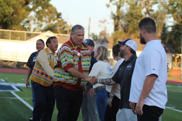 Richard Larney, a representative of the Ocese Band of Seminole Nation, and Seminole Nation Principal Chief Lewis J. Johnson shake hands with Shawnee Public Schools Board of Education President Clif Harden and other SPS employees during the recognition of the tribes at Jim Thorpe Night before the home football game on Sept. 27. Countywide &amp; Sun/Natasha Dunagan