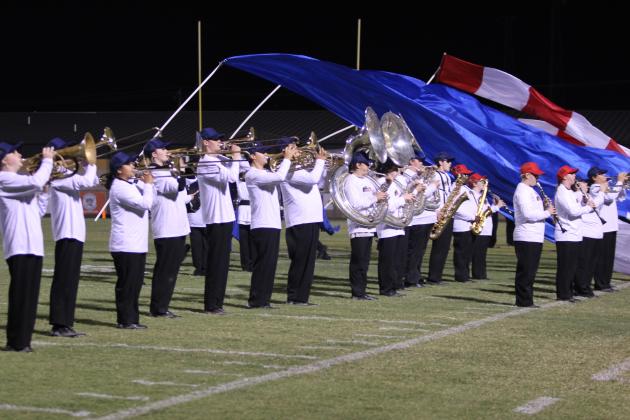 The Savage Pride Marching Band performs as the color guard begins running with U.S. flag banners in the background during halftime of the Oct. 10 home game with Blanchard. Countywide &amp; Sun/Natasha Dunagan