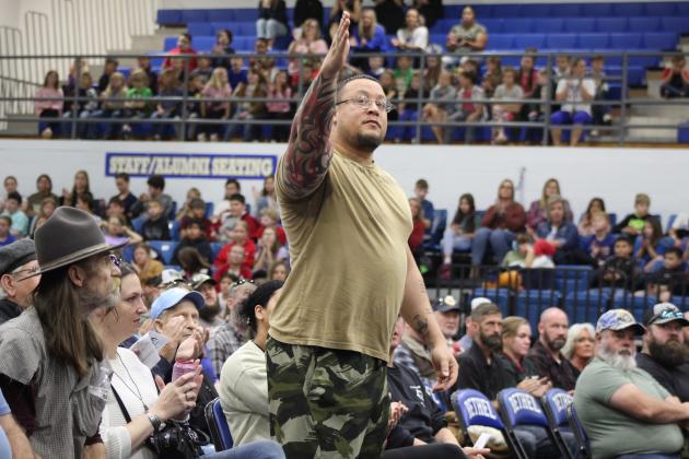 Veteran JaySean Clemente motions to someone in the audience as he is recognized during the "Introduction of Veterans" at the Bethel Public Schools Veterans Day Program on Nov. 11. Veterans also stood at the playing of their branch themes. Countywide &amp; Sun/Natasha Dunagan