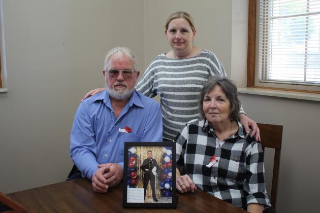 Darrell White, Master Sgt. Patricia White and Karen White pose on Veterans Day with a picture of Staff Sgt. Aaron White, who lost his life in a helicopter crash in Iraq in 2003. The picture is on display in the Gold Star Families Room of the new Pottawatomie County Veterans Museum, at the former District Attorney and Carnegie Library building. The Whites hope more Gold Star families will bring pictures for the room. Countywide &amp; Sun/Natasha Dunagan