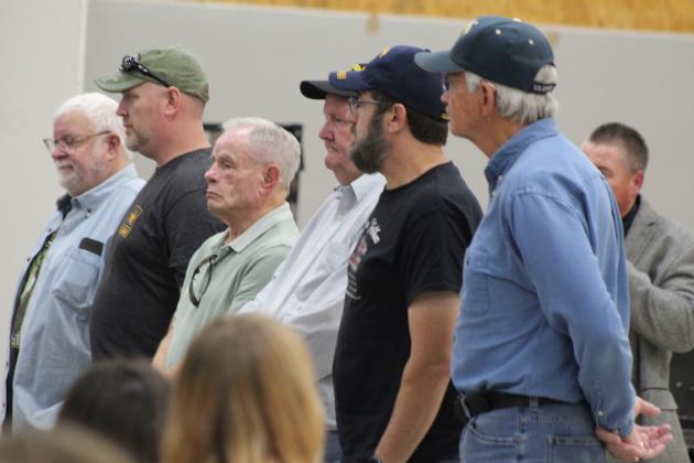 A row of veterans are recognized during the Tecumseh High School Veterans Day Ceremony, as Band Director John Outon speaks about the sacrifices made by those who served, on Nov. 11. Countywide &amp; Sun/Natasha Dunagan
