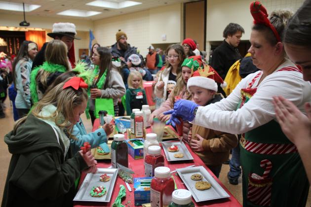Nicki Mills, with Tecumseh Pentecostal Church of God, helps kids to decorate cookies in Whoville, held in the Tecumseh City Hall Auditorium on Dec. 5. Countywide &amp; Sun/Natasha Dunagan