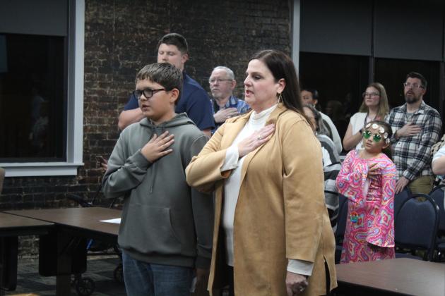 Shawnee fifth-grader Alex Sehaume and Will Rogers Elementary Principal Molly Wilson lead the flag salute during the Board of Education meeting on Dec. 2.