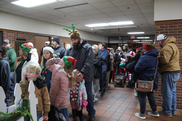 Families wait in the long line for free pictures with the Grinch.