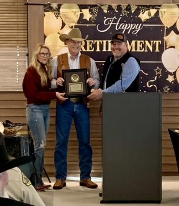 Mike Booth accepts a plaque for his retirement as Pottawatomie County Sheriff from County Commissioners Melissa Dennis and Greg Rush. Booth served as Sheriff for 16 years. Photo provided.