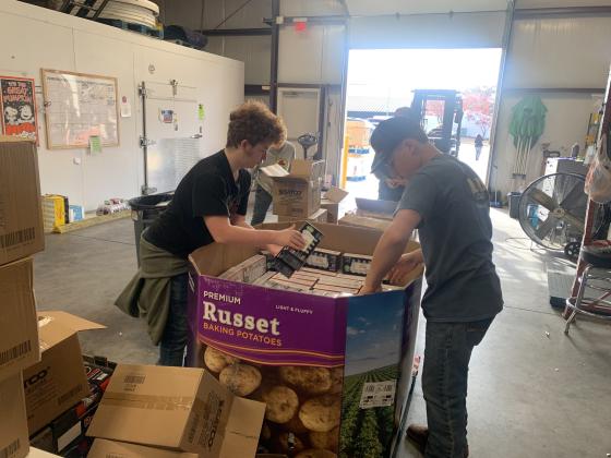 Dale FFA students organize boxes of lightbulbs at the Community Market of Pottawatomie County. Dale FFA placed second in the First United Bank Harvesting Impact contest in December 2024. North Rock Creek FFA placed first, and Shawnee High School FFA came in third. Photo provided by Jon Golliver.