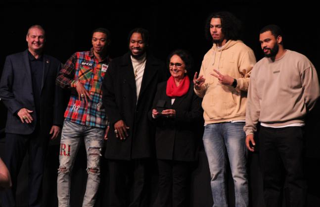 The Potawatomi Fire presented a 2024 National Championship ring necklace to Citizen Potawatomi Nation Vice Chair Linda Capps, fourth from left, during the Banquet &amp; Ring Ceremony. Also shown, from left, are Head Coach Mark Dannhoff, Chuck Guy, Assistant Coach Emmanuel Toney, Isaiah Wade and Deshawn Munson.