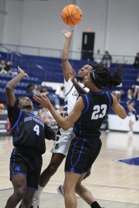 Shawnee senior Daytain Patton launches the ball over two Southeast players during the Shawnee Invitational game on Jan. 23. Countywide &amp; Sun/Natasha Dunagan