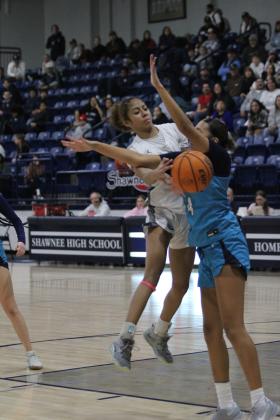 Shawnee junior Tarilyn Thierry passes the ball under the arms of an El Reno player at the Shawnee Invitational game on Jan. 25. Countywide &amp; Sun/Natasha Dunagan