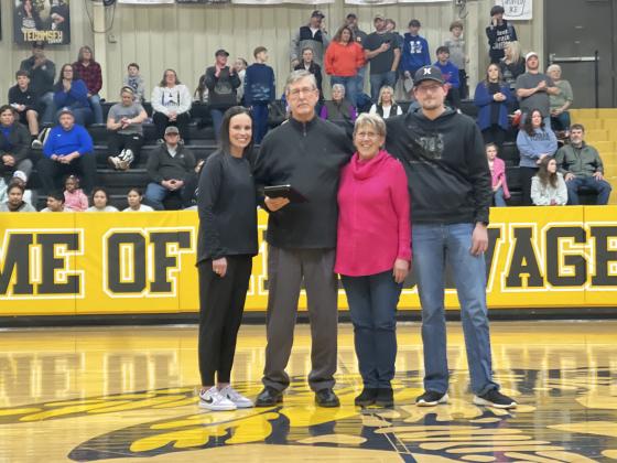 Tecumseh Athletic Director Casi Bays presents a plaque to Assistant Basketball Coach Bill Grogan in honor of his 50 years in coaching on Feb. 14. Also shown are his wife Jenni Grogan and son Todd Grogan. Photo provided by Casi Bays.
