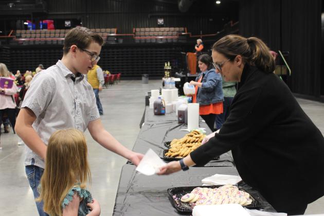Pottawatomie County 4-H Educator Kacie Jasper serves cookies at the Pottawatomie County Junior Livestock Show Pig Roast, held at FireLake Arena on Feb. 3. Countywide &amp; Sun/Natasha Dunagan