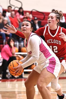 North Rock Creek's Jax Ratcliff looks at the basket with pressure from McLoud's Daycie Nemecek. The Lady Cougars won 61-45. The boys game was canceled due to illnesses. Photo courtesy of Gowin Photography