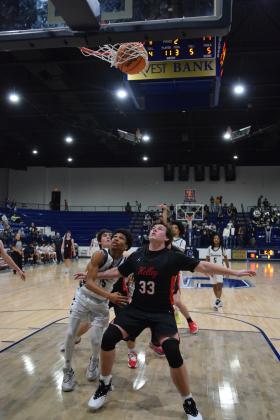 Isaiah Smith sinks his foul shot while Rah'Mel Slaughter tries for the rebound in the homecoming game against Bishop Kelley.  The Wolves lost 46-52. Countywide &amp; Sun/Julie Talton