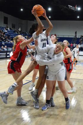 Tarilyn Thierry shoots from the tangled players while Allyson McAlister (front) and Josie Megehee (back) try to ward off defenders in the homecoming game against Bishop Kelley. The Lady Wolves pulled out the victory 54-33. Countywide &amp; Sun/Julie Talton