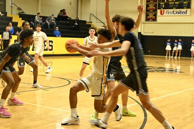 Tecumseh's Jekhi Owens guards the ball from Mount St. Mary's defenders during the Feb. 11 home game. The Savages lost, 63-88, and will play in the Class 4A District Tournament on Friday, Feb. 21, in Eufaula. Photo courtesy of Kenetta Lisenbee