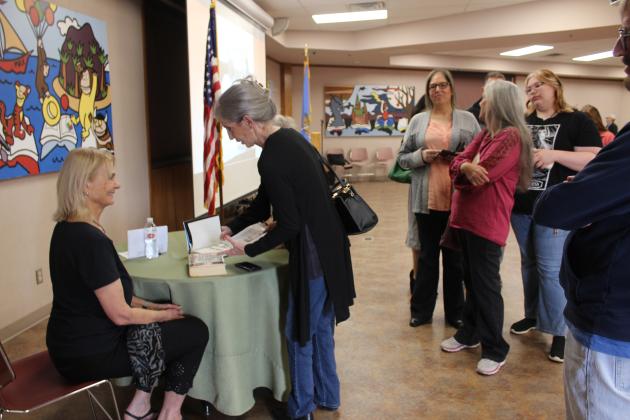 Diane (Grove) Smith speaks with author Anne Hillerman about signing an article and a book during the Oklahoma Literary Sites Register plaque dedication for the late Tony HIllerman at Shawnee Public Library on March 15. Smith's father, Joseph Grove, is a cousin of Tony Hillerman, Anne's father, and attended school in Sacred Heart with the late author. Mr. Hillerman never signed the book, "The Joe Leaphorn Mysteries," when he gave it to his cousin.