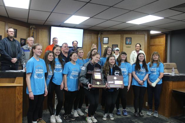 The Shawnee High School Girls Swim Team and their coaches Valarie Colburn and Bob McNeil pose with their Regional Champion and State Champion trophies during the Shawnee Public Schools Board of Education meeting on March 3. This is the fourth time in a row for the team to win state. By Natasha Dunagan, Countywide &amp; Sun