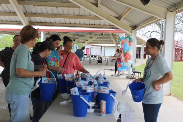 Indian Child Welfare Receptionist Vonda Dennis, far right, filled and gave away children's buckets full of goodies and information at the Sixth Annual Child Abuse Prevention Walk, held at the CPN Festival Grounds on April 18. The event is hosted by FireLodge Children &amp; Family Services and had 165 participants this year. Natasha Dunagan, Countywide &amp; Sun