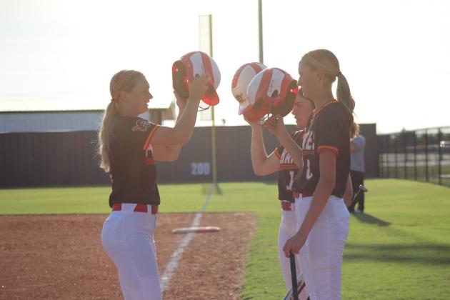 Dale's Heartly Snyder hits helmets with her teammates after slapping a home run during the game against Bethel at Shawnee on April 15. During the triple header, the Lady Pirates beat the Lady Wildcats, 9-7, and won against the Lady Wolves, 12-0. Natasha Dunagan, Countywide &amp; Sun