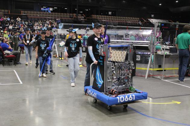 Following a playoff match, the Blue Phoenix Robotics Team from Shawnee wheel their robot, Sapphira, back to their pit area during the Oklahoma Regionals FIRST Robotics Competition, held at FireLake Arena on April 5. Eighth-graders from Grove School, they are, from left, Laura Farris, Daniel Bowlan, Conner Vorndran, Hudson McMains, Emma Knight and Jachin Dennis.