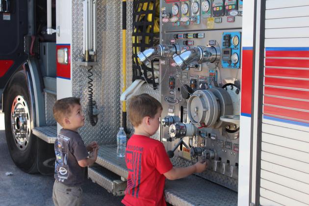 Connor Haynie, 4, and Rayden Presley, 5, both of Ada, look over the controls of a Bethel Acres Fire Department engine during the Touch A Truck and Beyond event, held at the Citizen Potawatomi Nation Festival Grounds on April 12.