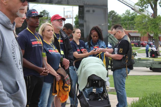 As U.S. Veterans Motorcycle Club Secretary River Thompson speaks at Woodland Veterans Park, Robert "Boomer" Baker, originally from Dale, passes out lanyards  to Gold Star family members during the Fifth Annual Gold Star Families Memorial Ride on May 24. After stopping at the Gold Star Families Monument, where a wreath was placed, they moved on to the Grand Casino Hotel and Resort for an indoor ceremony. Natasha Dunagan, Countywide &amp; Sun