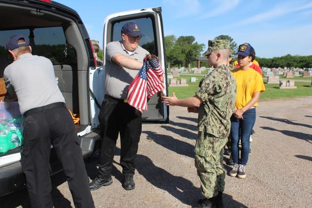 Alex Murray hands out bundles of flags.
