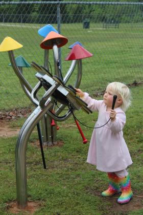 Ainsley Bingham, 2, of Tecumseh plays the Sunflower Petal Drum on the Pioneer Library System Music Trail. Tecumseh Public Library had a ribbon cutting on April 25 for six new struments, located along the northern trail of Slick Humphrey Park. Natasha Dunagan, Countywide &amp; Sun