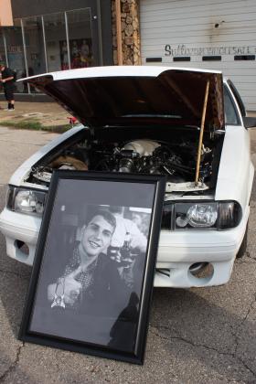 A picture of the late Christopher Stone of Earlsboro leans against his 1991 Ford Foxbody Mustang at the Downtown Auto at Sundown Car Show in Shawnee on June 14. Stone's father, Michael Stone, said they restored the car together, and he continues to work on it in the three years since his son passed away. C. Stone enjoyed racing the car, and his father had a get together for his friends to sign the hood.