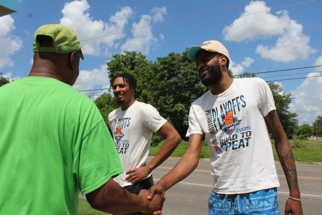 Rev. David Henry, owner of Epic Snocones, shakes hands with Potawatomi Fire player Jachai Simmons, as teammate K.T. Boucham looks on, during Epic Snocones' Juneteenth celebration on June 19. Henry invited the Potawatomi Fire team and also had a bouncehouse for the kids. Natasha Dunagan, Countywide &amp; Sun