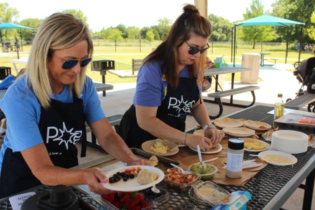 Pottawatomie Go (POGO) volunteers Kim White and Beth Beshears plate up samples of breakfast burritos during a cooking demonstration at the Fun Day at Kidspace Park on May 30. Fun Day was part of Health Week, which is sponsored by the Avedis Foundation, and offered a variety of activities in the morning and evening. Several of the events were sponsored by POGO.