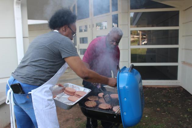 Yolanda Simon and Albert Rice work on grilling burgers for Juneteenth.
