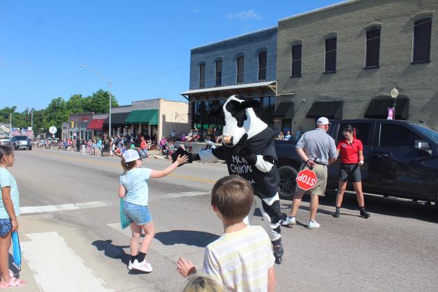 The Chick-Fil-A Cow gives a high five.