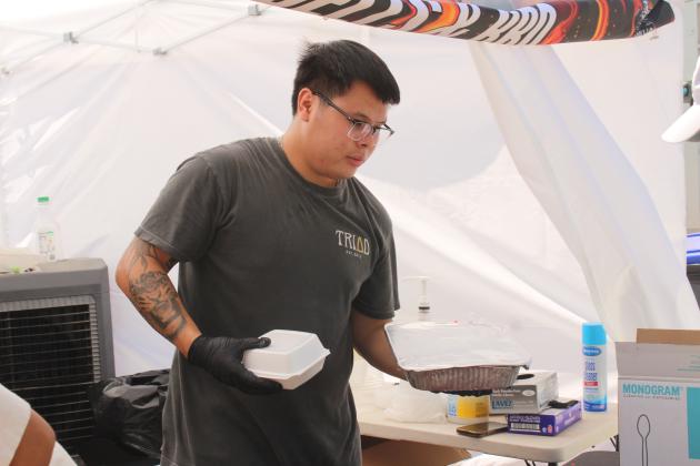 Tyler Nguyen of Barbells &amp; BBQ serves a whole blackberry cobbler and a slice.