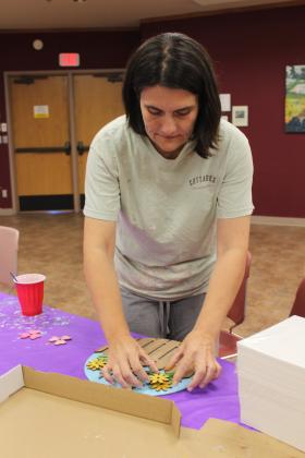 Bree VanDyne of Shawnee works on assembling her door sign project at the "Paint Together" event at Shawnee Public Library on June 10. The painting instructor who was scheduled to lead the class was not available, so library staff had to improvise. Visit the Pioneer Library Systems website to see a full calendar of summer programs.