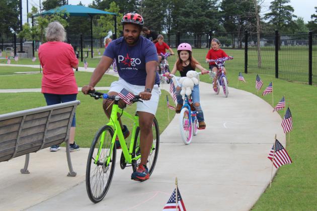 John Bobb-Semple, Executive Director of Pottawatomie Go, serves as the kids'  parade marshal, during the First Annual Freedom Fest at Kidspace Park on July 5. He led about 14 children on bikes, scooters and tricycles. Prizes were given for Most Patriotic, Most Enthusiastic and Most Creative. Hosted by Shawnee Parks and Recreation and POGO, they also had sidewalk chalk art contest.