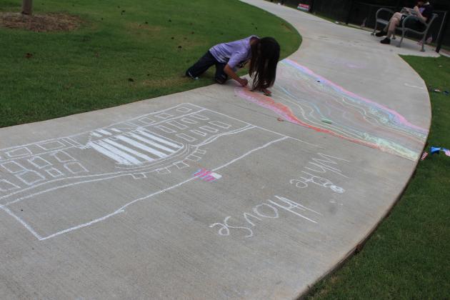 Prestynn Neely works on her chalk art. Her sister Peyton drew the White House.