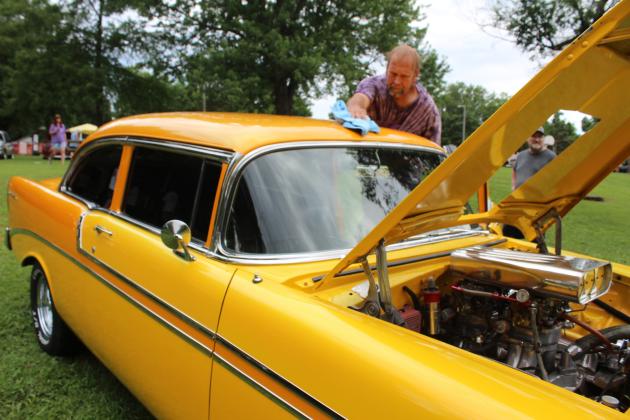 Bob West of Shawnee wipes the rainwater off his 1956 Chevy Belair during the 38th Annual Knights Auto Club Car Show on June 28 at Boy Scout Park in Shawnee. West said the yellow paint turns green in bright sunshine. The event featured 203 entries and 11 club cars, said Lisa Schultz with the Knights in an email.