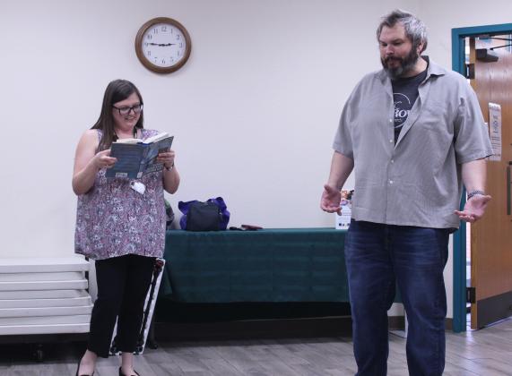 McLoud librarian Trisha Bias and Roger Connelly, with OKC Improv, act out a scene in which Bias can only respond with lines from a book and Connelly tries to diffuse an imaginary bomb like in the show "MacGyver." Connelly was the moderator, leading a group of three other actors from OKC Improv with audience participation, during this event at McLoud Public Library on July 22.