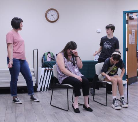 Elizabeth Dragoo and Katherine McKay, of OKC Improv, play college roommates, as McLoud librarian Trisha Bias and audience member Alex, both seated, provide lines and can't help but laugh during the McLoud Public Library event on July 22.