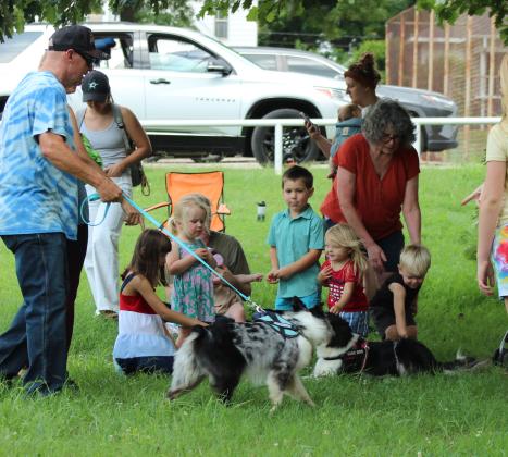 Children enjoy petting Miss Demeanor, walked by Jeff Savage, and Suzie Q of the Tornado Alley Disc Dogs following their performance at Boy Scout Park on July 12.  This was a Shawnee Public Library Summer Learning Challenge event. Visit pioneerlibrarysystem.org to see upcoming events.
