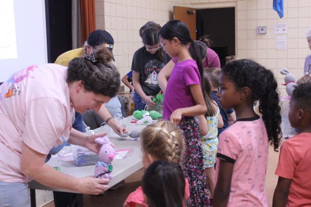 After hot gluing on the eyes, nose and tail and separating the ears, Tecumseh Head Librarian Beth Lyle shows a girl her 'Muttigree' buddy during the Jasmine Moran Children's Museum event at the library on July 17.