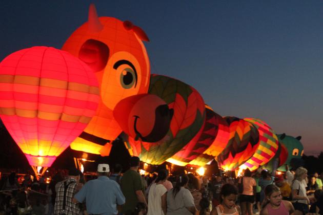 A line of hot air balloons light up on Aug.9 - including "Milky Way," which is shaped like a cow, and a new llama-shaped balloon - during the FireLake Fireflight Balloon Festival at the CPN Festival Grounds. As in the past few years, there were 25 balloons from all over the U.S., but they were unable to offer rides this year due to the wind speeds.