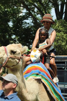 Sabina Dindy and her daughter, Deja Dindy, 5, both of Edmond, ride on a camel led by Michael Massey of Camels Unlimited in the Kids' Zone of the FireLake Fireflight Balloon Festival on Aug. 9. This is the second year for the festival to offer camel rides, and they were included with the purchase of a wrist band.