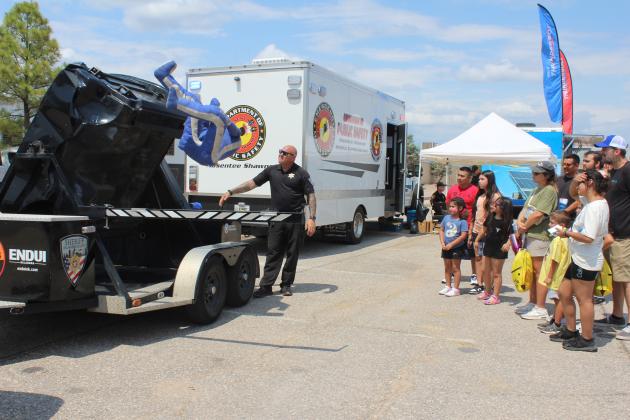 Oklahoma Highway Patrol Master Sgt. Eric Kirby demonstrates what happens during a rollover when an adult doesn't wear a seatbelt during Cops N' Kids on Aug. 23.