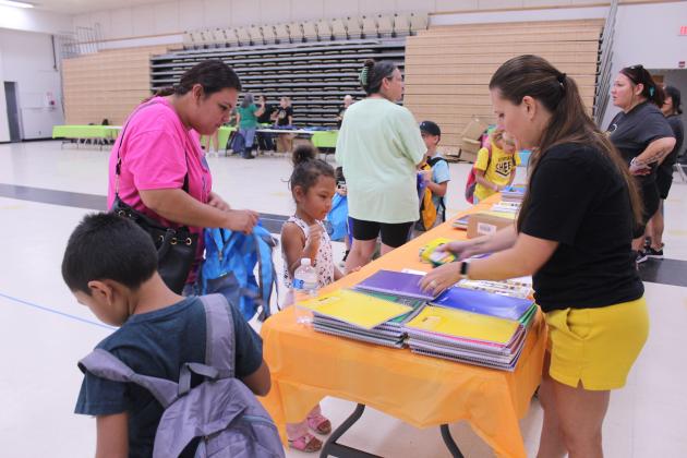 Melissa Bartmess, right, helps a first-grader to pick out supplies during Mission Tecumseh's 11th Annual Back to School Bash at the W.P. Wood Alumni Center on July 26.